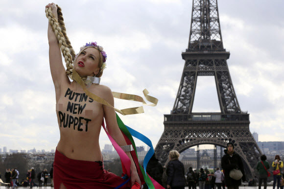25일(현지시간) 여성 인권단체 페멘(Femen)회원이 상의를 탈의한 채 파리 에펠탑 앞에서 우크라이나 율리아 티모셴코 전 총리에 항의하는 시위를 하고 있다.  로이터/뉴스1