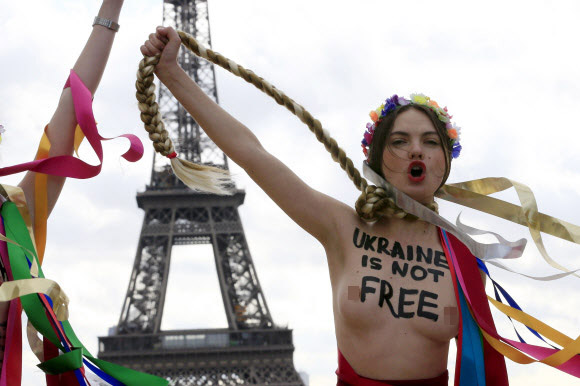 25일(현지시간) 여성 인권단체 페멘(Femen)회원이 상의를 탈의한 채 파리 에펠탑 앞에서 우크라이나 율리아 티모셴코 전 총리에 항의하는 시위를 하고 있다.  로이터/뉴스1
