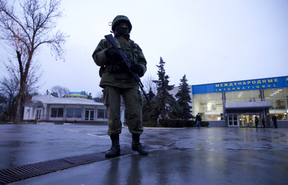 우크라이나 크림 자치공화국 심페로폴 공항에서 28일 한 남자가 총을 든 채 경비를 서고 있다. 군복을 입은 무장 세력들은 이날 새벽 러시아 국기를 들고 공항을 점거했다가 물러났다. 심페로폴 AP 연합뉴스