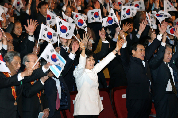 박근혜(가운데) 대통령이 1일 서울 종로구 세종문화회관에서 열린 제95주년 3·1절 기념식에서 애국지사 및 3부 요인들과 함께 태극기를 들고 만세삼창을 하고 있다.  청와대사진기자단