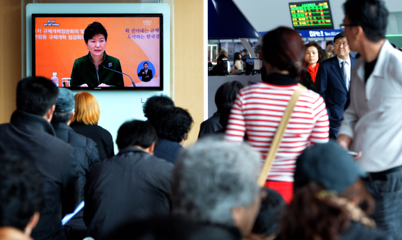 20일 서울 용산구 서울역 대합실에서 시민들이 대형 TV를 통해 생중계되는 ‘규제개혁 끝장 토론’을 시청하고 있다. 