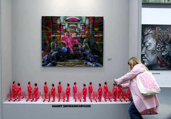 26일 파리에서 개막된 파리아트페어를 찾은 관람객이 태국 조각가 마니트 스리와니츠품(Manit Sriwanichpoom)의 작품 ‘핑크맨:소비주의의 아이콘’을 유심히 보고 있다.ⓒ AFPBBNews=News1