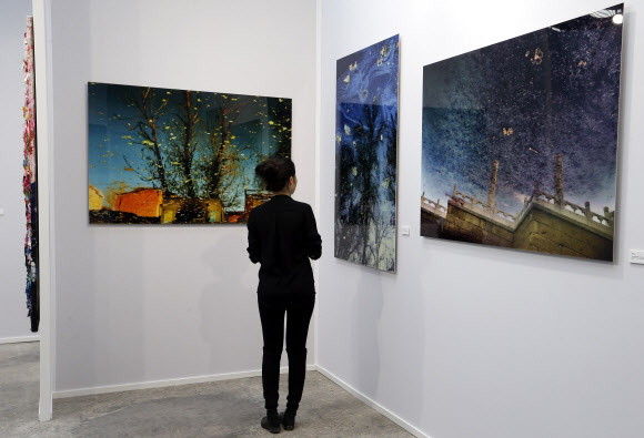 26일 파리에서 개막된 파리아트페어를 찾은 관람객이 작가 한 빙(Han Bing)의 작품을 유심히 보고 있다.ⓒ AFPBBNews=News1