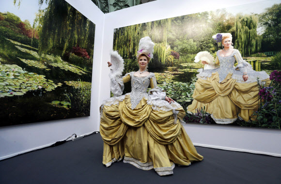 26일 파리에서 개막된 파리아트페어를 찾은 관람객이 이갈 오제리(Yigal Ozeri)의 작품 앞에서 사진과 같은 옷을 입은 모델이 포즈를 취하고 있다.ⓒ AFPBBNews=News1