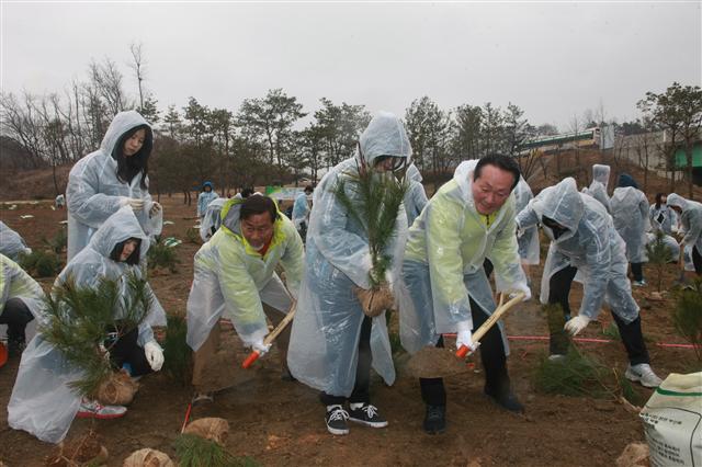 김학송(오르쪽 두 번째) 한국도로공사 사장이 지난 12일 ‘통일희망나무’ 첫 식재 현장인 수원나들목 녹지대에서 직원들과 함께 나무를 심고 있다. 도공은 2016년까지 고속도로 부지에 1만 5000그루를 심는다. 한국도로공사 제공