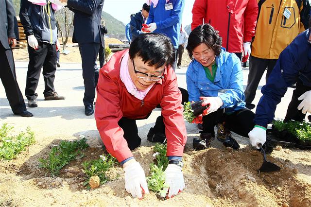 이동필(왼쪽) 농림축산식품부 장관이 8일 충북 영동군 모리마을을 방문해 ‘농촌마을 가꾸기 운동’을 벌이며 마을 주민들과 함께 꽃을 심고 있다. 농식품부 제공