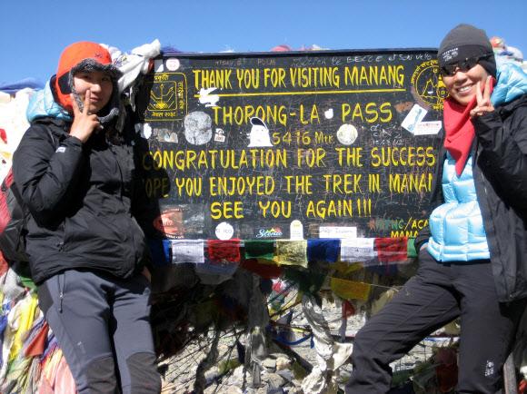 지난해 9월 네팔 히말라야의 안나푸르나 종주에 도전한 소설가 정유정(오른쪽). 해발 5400m가 넘는 ‘소롱라패스’의 표지판 앞에서 동료 작가 김혜나와 함께 기념촬영을 하고 있다.  은행나무 제공
