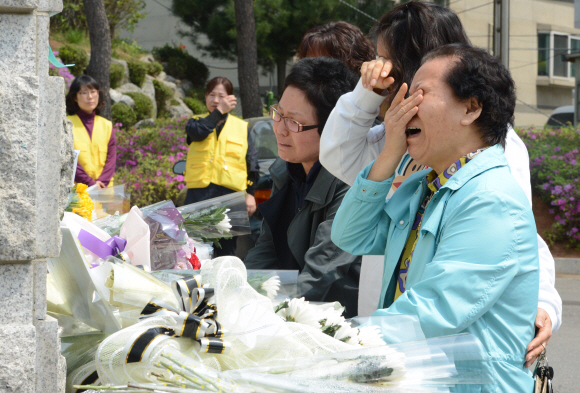 세월호 침몰 엿새째인 21일 희생된 학생들을 추모하기 위해 경기 안산 단원고등학교 정문에 모인 시민들이 끝내 울음을 참지 못하고 오열하고 있다. 