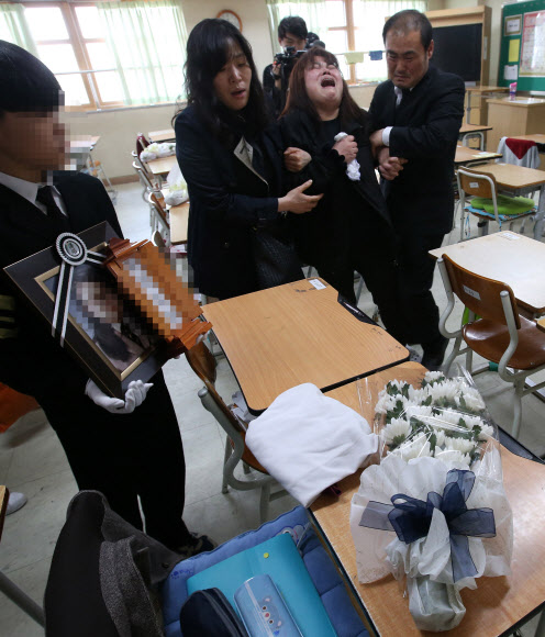 여객선 세월호 침몰 사고 일주일째인 22일 오전 희생 학생의 장례식이 열려 경기도 안산 단원고등학교 2학년 교실 국화꽃이 놓인 자리에서 유가족들이 오열하고 있다.  연합뉴스