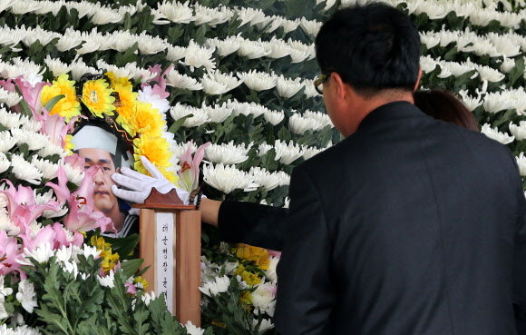 22일 오전 해군 제주방어사령부 연병장에서 세월호 사고 현장에 구조지원 가던 대조영함에서 사고로 숨진 윤모(21) 병장 영결식이 해군 제7전단장장으로 엄수된 가운데 윤 병장의 어머니가 분향하기 전 영정을 만져보고 있다.  연합뉴스