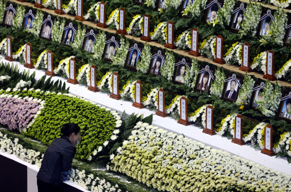 24일 경기도 안산 올림픽기념관에 마련된 침몰 세월호 단원고 희생자를 위한 임시 합동분향소에 시민이 헌화하며 눈물 흘리고 있다. 연합뉴스