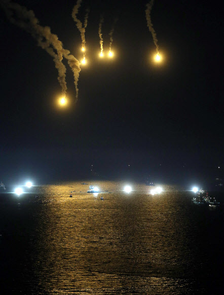 24일 오후 여객선 ’세월호’가 침몰한 전남 진도군 조도면 병풍도 북쪽 3km 앞 사고 해상에서 채낚이 어선과 조명탄이 불을 밝히는 가운데 야간 수색 작업이 진행되고 있다. 연합뉴스