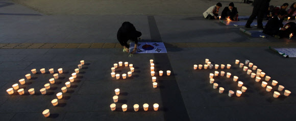 시민단체 민주실현시민운동본부 주최로 24일 저녁 서울 중구 정동 덕수궁 대한문 앞에서 열린 세월호 무사생환 염원 촛불집회에서 참석자들이 촛불로 만든 ’미안해’라는 글씨가 바닥에 새겨져 있다.  연합뉴스