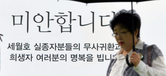 27일 서울 시청에 걸린 세월호 추모 글귀 앞을 시민들이 지나고 있다. 박지환 기자 popocar@seoul.co.kr