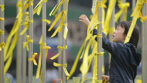 2일 서울 시청광장을 찾은 어린이가 기둥에 노란 리본을 묶고 있다. 박지환 popocar@seoul.co.kr