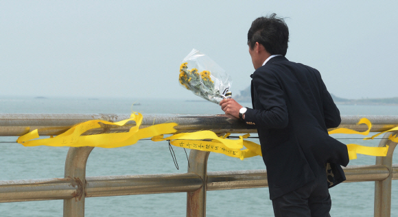 세월호 침몰 사고 17일째인 2일 전남 진도군 임회면 팽목항을 찾은 한 시민이 희생자들을 애도하기 위한 꽃다발을 들고 바다를 바라보고 있다.  진도= 손형준 boltagoo@seoul.co.kr