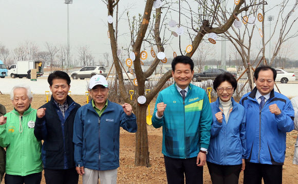 6·4 지방선거 인천시장 재선에 도전하는 송영길(오른쪽에서 세 번째) 시장이 지난달 11일 인천 서구 2014인천아시아경기대회 주경기장에서 열린 ‘저탄소 친환경 스포츠 축제 기원 이마트 희망나무 숲 가꾸기’ 행사에 참석해 관계자들과 기념촬영을 하고 있다.  연합뉴스