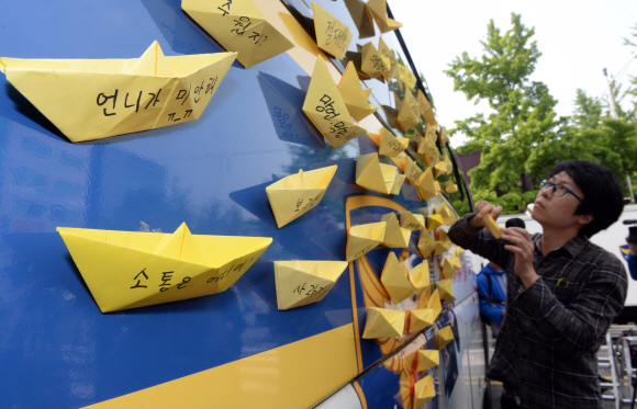 9일 서울 종로구 청운동사무소 앞에서 세월호 침몰사고 희생자 유가족들이 대통령과의 대화를 요구하고 있는 가운데 시민들이 노란종이배를 경찰버스에 붙이고 있다.  정연호 기자 tpgod@seoul.co.kr