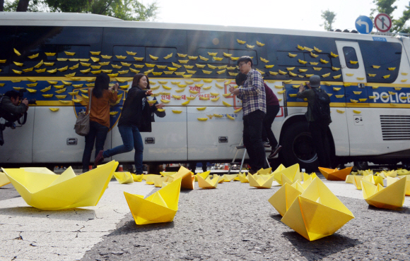 9일 서울 종로구 청운동사무소 앞에서 세월호 침몰사고 희생자 유가족들이 대통령과의 대화를 요구하고 있는 가운데 시민들이 노란종이배를 경찰버스에 붙이고 있다.  정연호 기자 tpgod@seoul.co.kr