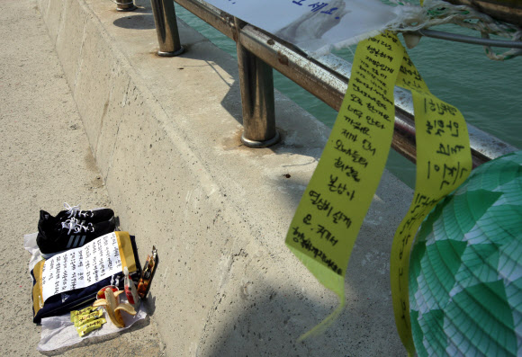 세월호 침몰 사고 28일째인 13일 오전 전남 진도군 임회면 팽목항 방파제에 한 실종자 가족이 아들에게 가져다 놓은 운동화, 트레이닝복, 편지 등이 놓여 있다. 연합뉴스