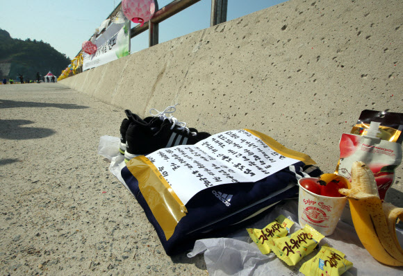 세월호 침몰 사고 28일째인 13일 오전 전남 진도군 임회면 팽목항 방파제에 한 실종자 가족이 아들에게 가져다 놓은 운동화, 트레이닝복, 편지 등이 놓여 있다. 연합뉴스