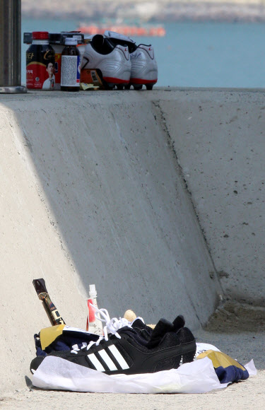 세월호 침몰 사고 28일째인 13일 오전 전남 진도군 임회면 팽목항 방파제에 실종자 가족들이 가져다 놓은 운동화들이 바다를 향해 놓여 있다.  연합뉴스