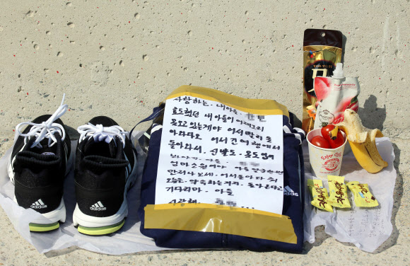 세월호 침몰 사고 28일째인 13일 오전 전남 진도군 임회면 팽목항 방파제에 한 실종자 가족이 아들에게 가져다 놓은 운동화, 트레이닝복, 편지 등이 놓여 있다. 연합뉴스