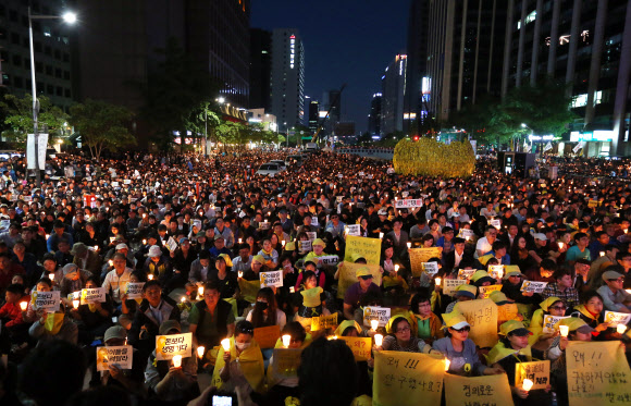 17일 오후 서울 중구 청계광장에서 세월호 추모 촛불 집회가 열려 참석자들이 촛불을 들고 있다.  연합뉴스