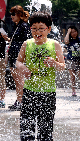 초여름 날씨를 보인 18일 서울 광화문광장의 분수대를 찾은 어린이들이 뿜어져 나오는 물줄기를 가로지르며 즐거워 하고 있다. 이종원 선임기자 jongwon@seoul.co.kr
