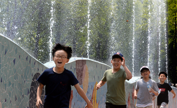 초여름 날씨를 보인 18일 서울 광진구 능동 어린이대공원을 찾은 어린이들이 뿜어져 나오는 분수를 뛰놀며 즐거워 하고 있다. 이종원 선임기자 jongwon@seoul.co.kr