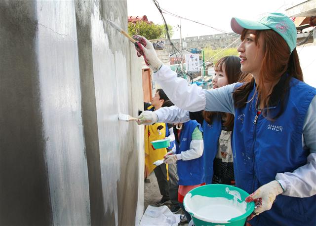 그림에 소질이 있는 삼성전자 임직원들이 지난달 19일 경기 수원시 지동 벽화마을에서 벽화 그리기 봉사활동을 하고 있다. 삼성전자 제공
