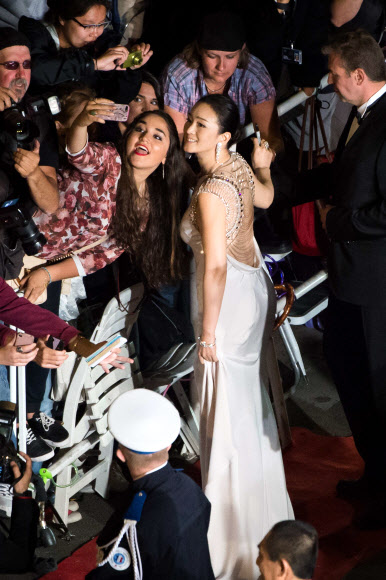 중국 여배우 공리(Gong Li)가 여성팬의 사진촬영에 밝은 미소로 답하고 있다.