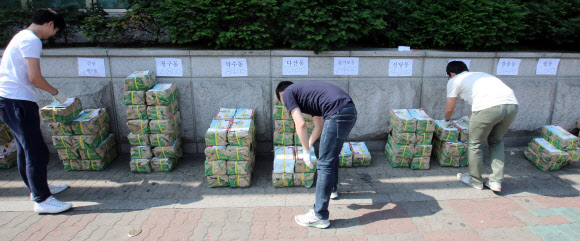 서울 중구 선거관리위원회 관계자들이 22일 오전 서울 을지로6가 선관위 앞에서 각 동 주민센터로 발송할 선거 공보를 분배하고 있다.  연합뉴스