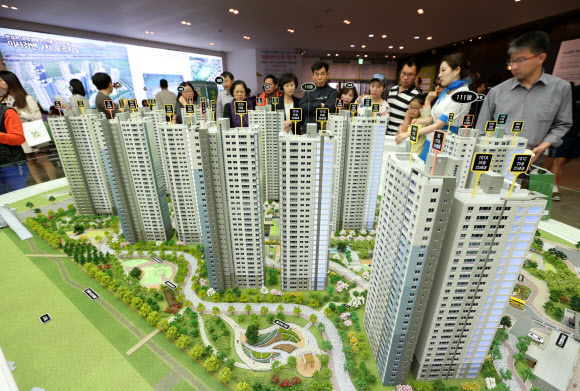 모델하우스를 방문한 관람객들이 모형 아파트를 살펴보고 있다.  연합뉴스