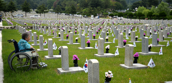 제59회 현충일을 닷새 앞둔 1일 서울 동작구 국립서울현충원에서 휠체어를 탄 한 참배객이 묘비 앞에서 고인을 추모하고 있다. 박지환 기자 popocar@seoul.co.kr