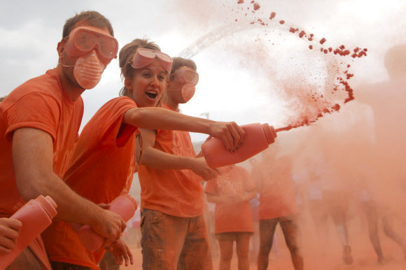 1일(현지시간) 영국 런던의 웸블리 스타디움에서 열린 컬러런(Colour Run)에 참가한 참가자들이 주황색 가루를 맞으며 즐거워하고 있다. ⓒ AFPBBNews=News1
