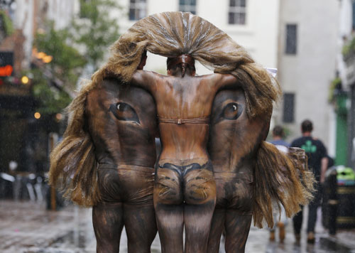3일(현지시간) 런던동물원의 사자 보호 기념 행사로 온 몸에 바디 페인팅으로 사자의 머리를 그린 모델들이 런던 카나비 거리 중심에서 포즈를 취하고 있다. 사진제공=AP/뉴시스