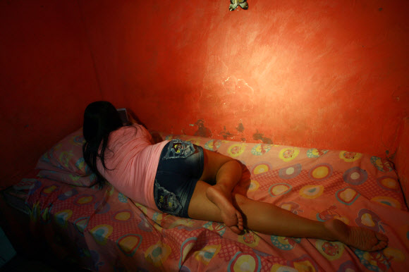 동남아 최대의 매춘업소 밀집지역 중 한 곳인 인도네시아 수라바야시 돌리 구역에서 한 성매매 여성이 벽을 향해 누워 있다. 사진 ⓒ AFPBBNews=News1 / 온라인뉴스부 iseoul@seoul.co.kr