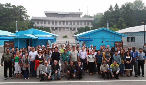 한국기자협회가 주최하는 제2회 세계기자대회에 참가한 세계 50여개국 기자들이 17일 경기 파주시 판문점을 찾아 군사정전위 회담장과 북측 지역인 판문각을 배경으로 기념촬영을 하고 있다. 한국기자협회 제공