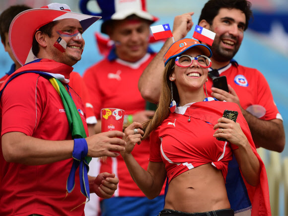19일(한국시간) 오전 4시 브라질 히우데자네이루 에스타디오 마라카낭 경기장에서 열린 2014 FIFA 브라질월드컵 B조 조별예선 2차전 스페인과 칠레의 경기에서 칠레의 한 여성 축구팬이 티셔츠의 한쪽을 묶어 입고 열심히 응원 중이다. 이날 칠레가 스페인을 2-0으로 이겨 B조 승점 3점에 도달했다. 사진 ⓒ AFPBBNews=News1/ 온라인뉴스부 iseoul@seoul.co.kr