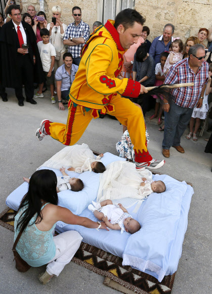 스페인의 카스드릴로 드 무르시아라는 도시에서 ‘엘 콜라초(아기 뛰어넘기 축제)’ 기간 중인 22일(현지시간) 악령으로 분장한 한 남자가 매트리스에 누워있는 아기들을 뛰어넘고 있다. 사진ⓒAFPBBNews=News1/ 온라인뉴스부 iseoul@seoul.co.kr