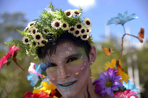 콜롬비아 안티오키아주 메델린 지역에서 게이 프라이드 퍼레이드를 맞아 한 남성이 꽃과 화장으로 여성스럽게 분장을 한 후 카메라를 향해 포즈를 취하고 있다. 사진 ⓒ AFPBBNews=News1/ 온라인뉴스부 iseoul@seoul.co.kr
