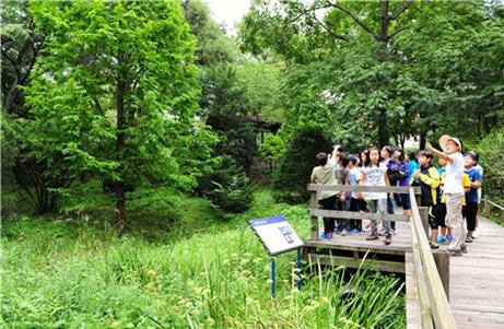 동대문구의 아토피 가족 힐링캠프 참가자들이 국립산림과학원을 찾아 숲과 아토피에 대한 이야기를 듣고 있다.<br>동대문구 제공
