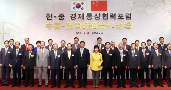 박근혜(왼쪽에서 여덟 번째) 대통령과 시진핑(일곱 번째) 중국 국가주석이 4일 서울 중구 장충동 신라호텔에서 열린 한·중 경제통상협력포럼에 참석해 한·중 기업인들과 함께 기념사진을 찍고 있다. 청와대사진기자단