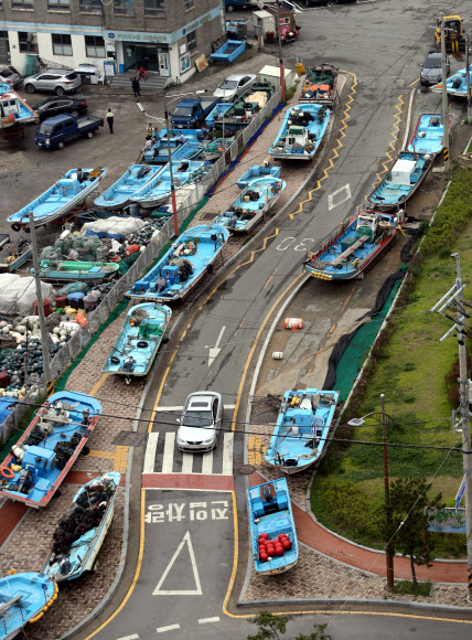 태풍 ‘너구리’ 북상… 도로위 대피 어선  제8호 태풍 ‘너구리’가 북상하는 가운데 7일 부산 해운대구 송정해수욕장 인근 도로에 태풍 피해를 방지하기 위해 옮겨진 어선들이 줄지어 서 있다.<br>부산 연합뉴스