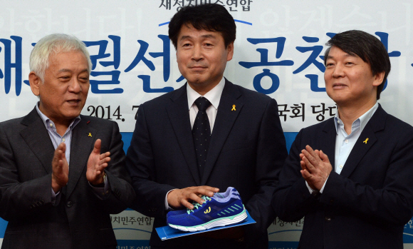 기동민(가운데) 새정치민주연합 후보도 김한길(왼쪽)·안철수 공동대표로부터 공천장과 함께 열심히 뛰라는 의미로 운동화를 선물 받고 있다. 이종원 선임기자 jongwon@seoul.co.kr
