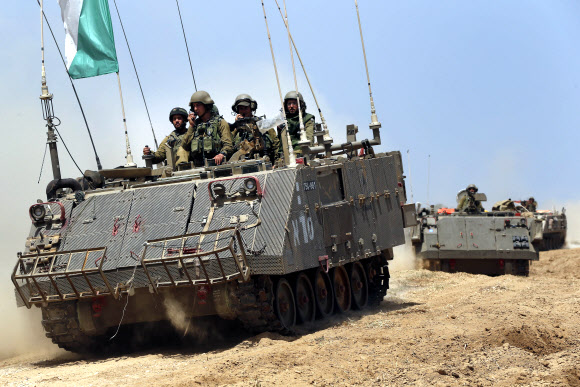 12일(현지시간) 중무장한 이스라엘군 병사들이 장갑차를 타고 이스라엘과 팔레스타인 가자지구 접경지역의 새 작전지로 이동하고 있다. 유엔이 휴전을 촉구하고 있음에도 이스라엘은 가자지구 북부 지역 내 하마스 세력을 궤멸시키겠다며 지상군을 투입하는 한편 주민 소개령까지 발동했다. 가자지구 AP 연합뉴스
