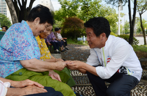 7·30 재·보궐 선거에 나선 경기 평택을 유의동(오른쪽) 새누리당 후보가 18일 세교동 주민센터 앞에서 유권자들에게 명함을 건네며 지지를 호소하고 있다. 