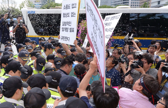 전국농민회총연맹, 전국여성농민회총연합, 가톨릭농민회 대표들이 18일 정부서울청사 앞에서 정부의 쌀 개방을 규탄하며 쌀을 뿌리는 시위를 하고 있다. 