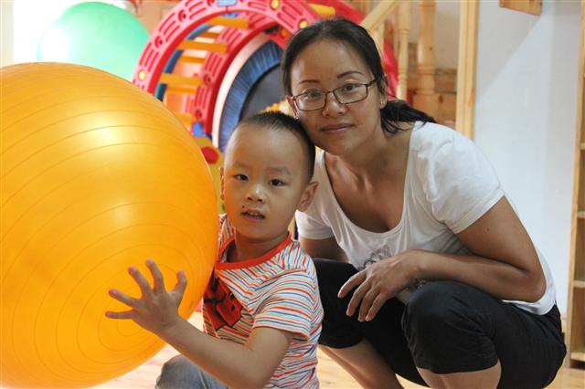 중국 쓰촨성 대지진이 발생했던 2008년 5월 당시 아들을 잃었던 중리가 지난 5일 참사 이후 어렵게 얻은 둘째 아들 옌과 함께 웃고 있다.